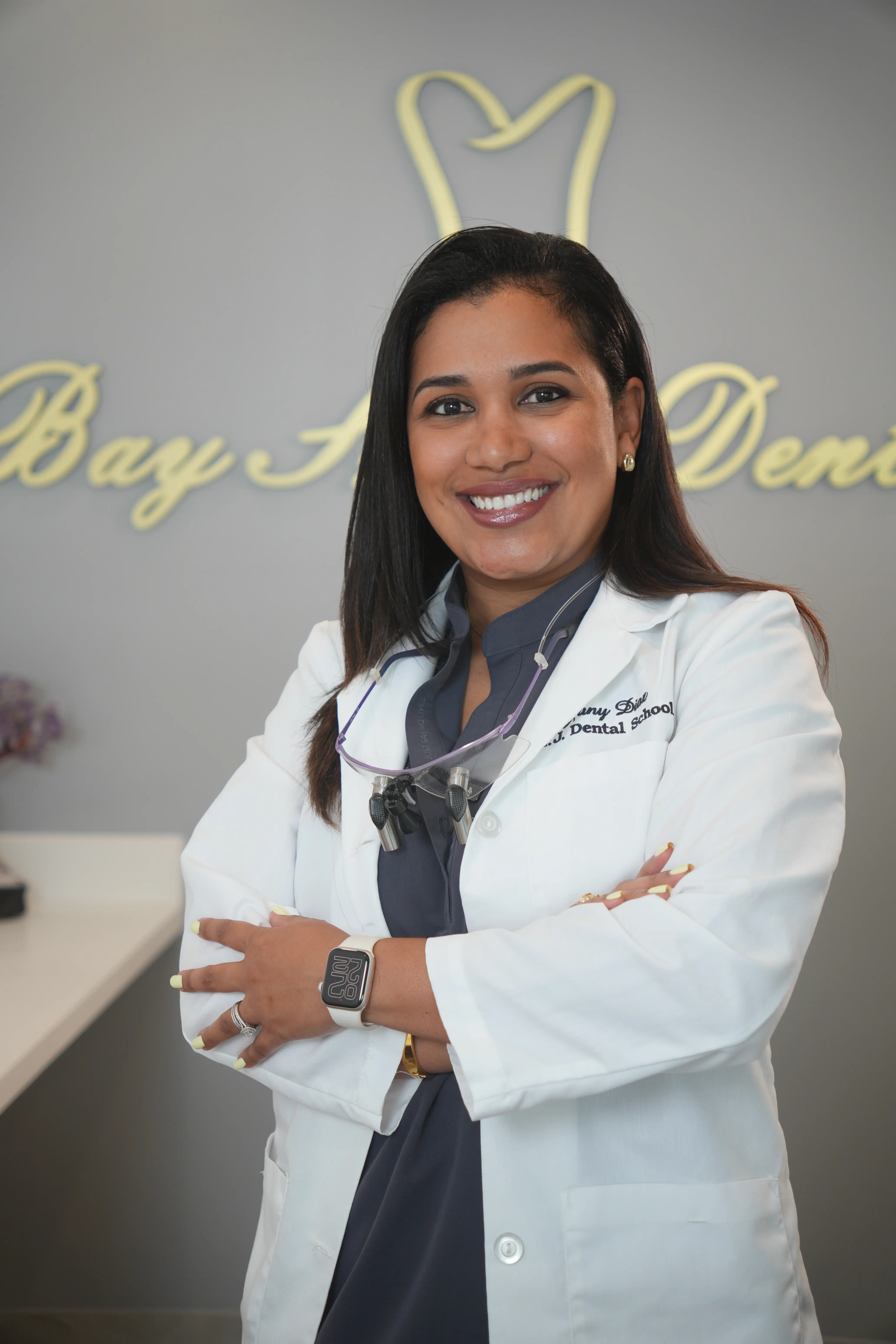Professional portrait of confident female dentist in clean minimalist white coat standing in a bright modern clinic